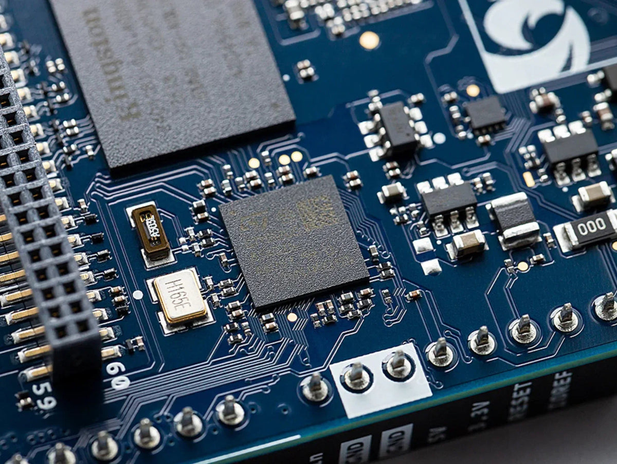 Close-up of Arduino UNO Q circuit board components, pin headers and surface-mounted processor