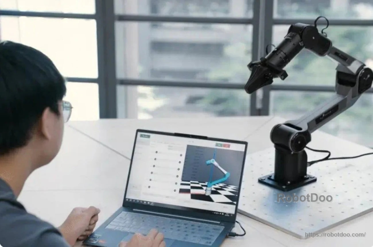 Developer using a laptop to control a desktop PiPER robot arm with a 3D visualization and trajectory interface