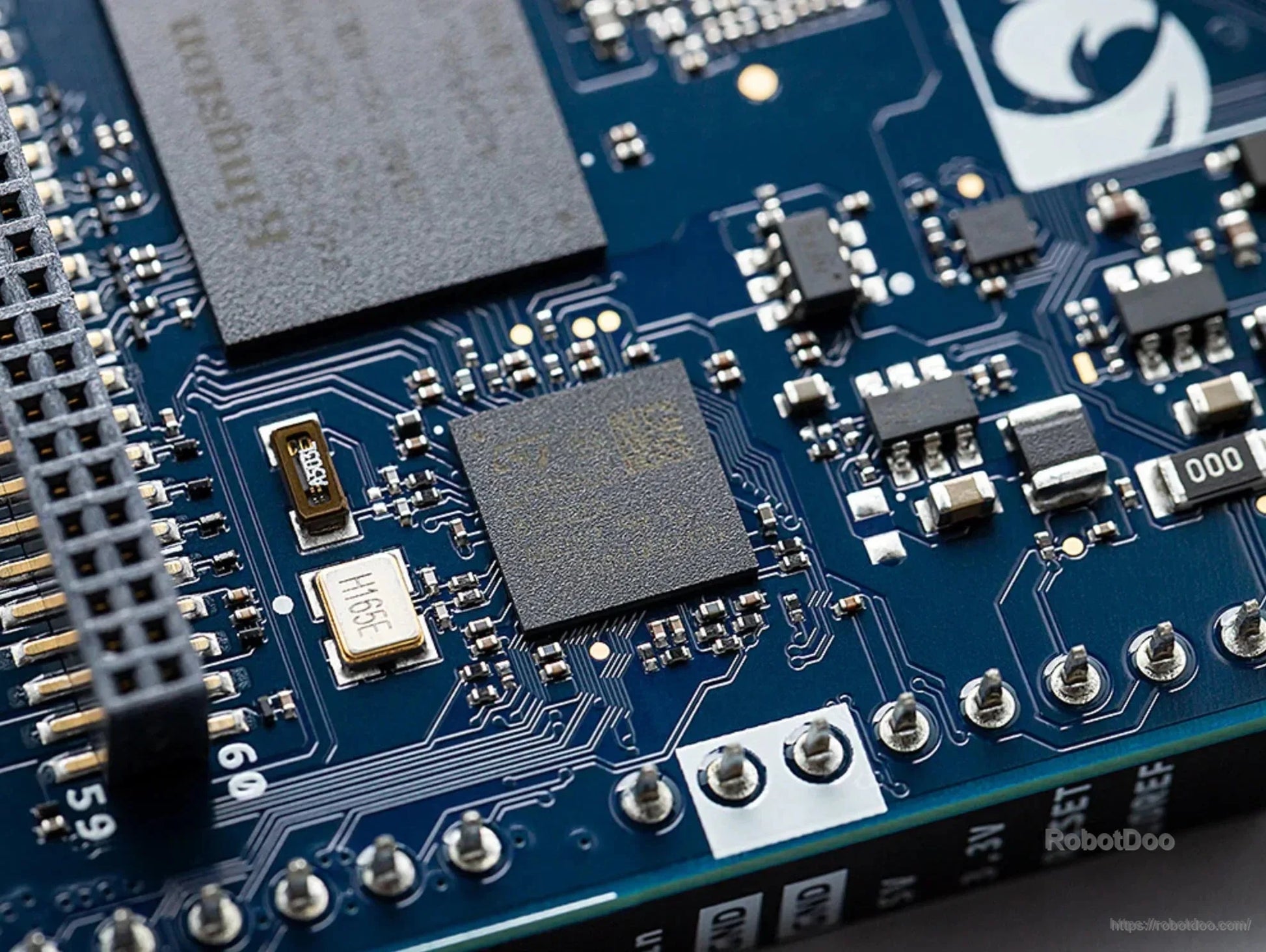 Close-up of Arduino UNO Q circuit board components, pin headers and solder connections