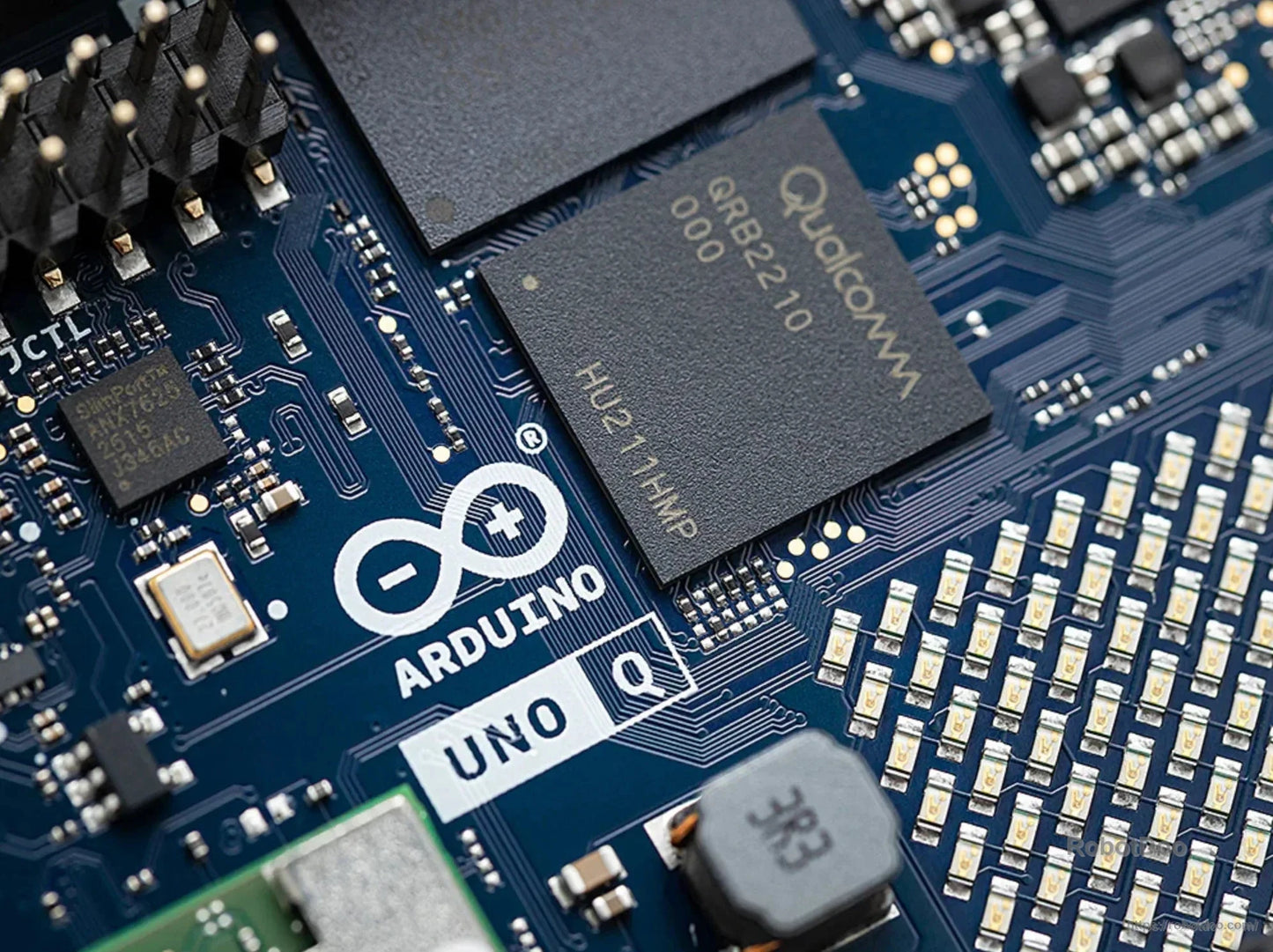Close-up of Qualcomm QRB2210 chip and Arduino UNO Q logo on the development board