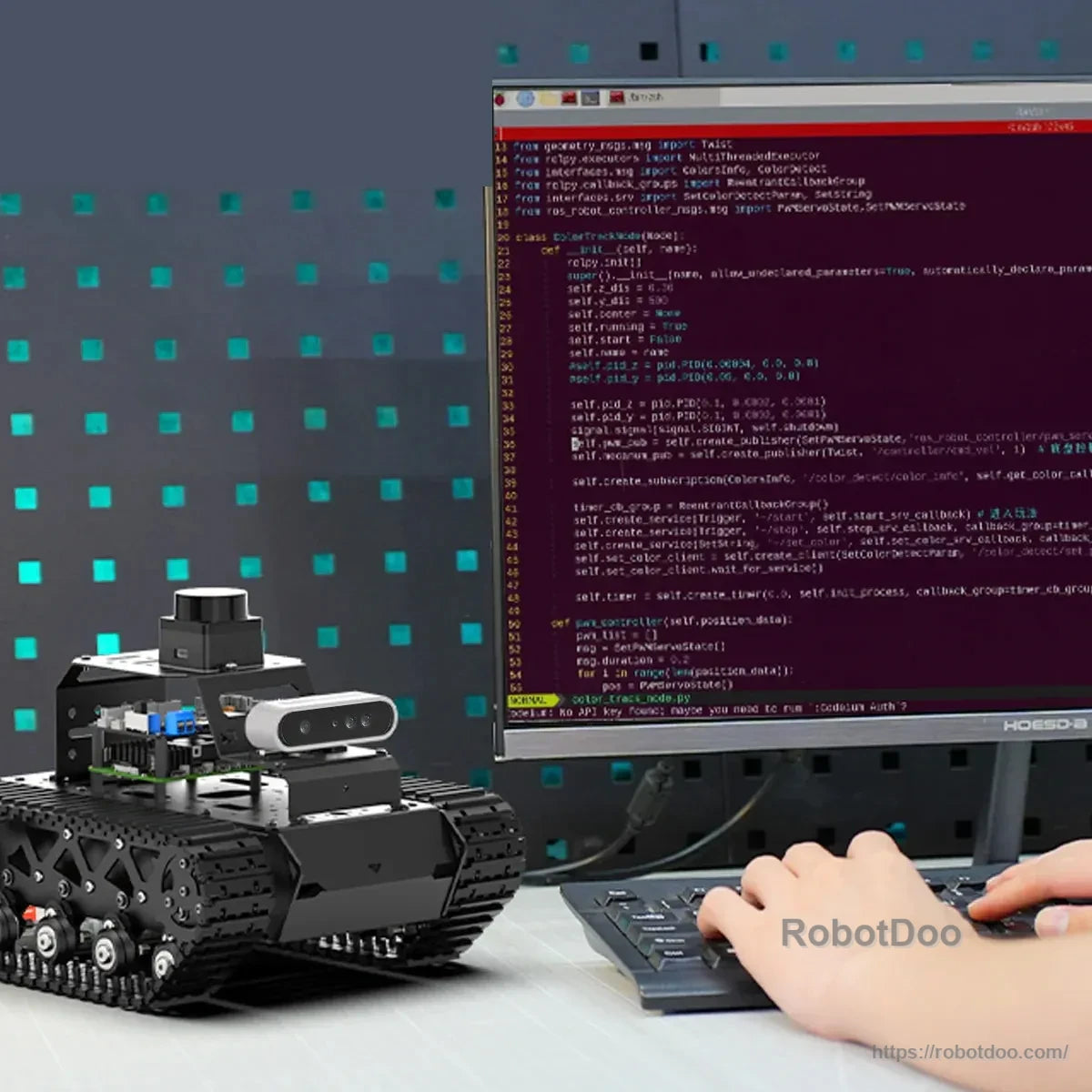 Tracked ROS2 robot beside a computer screen displaying programming code
