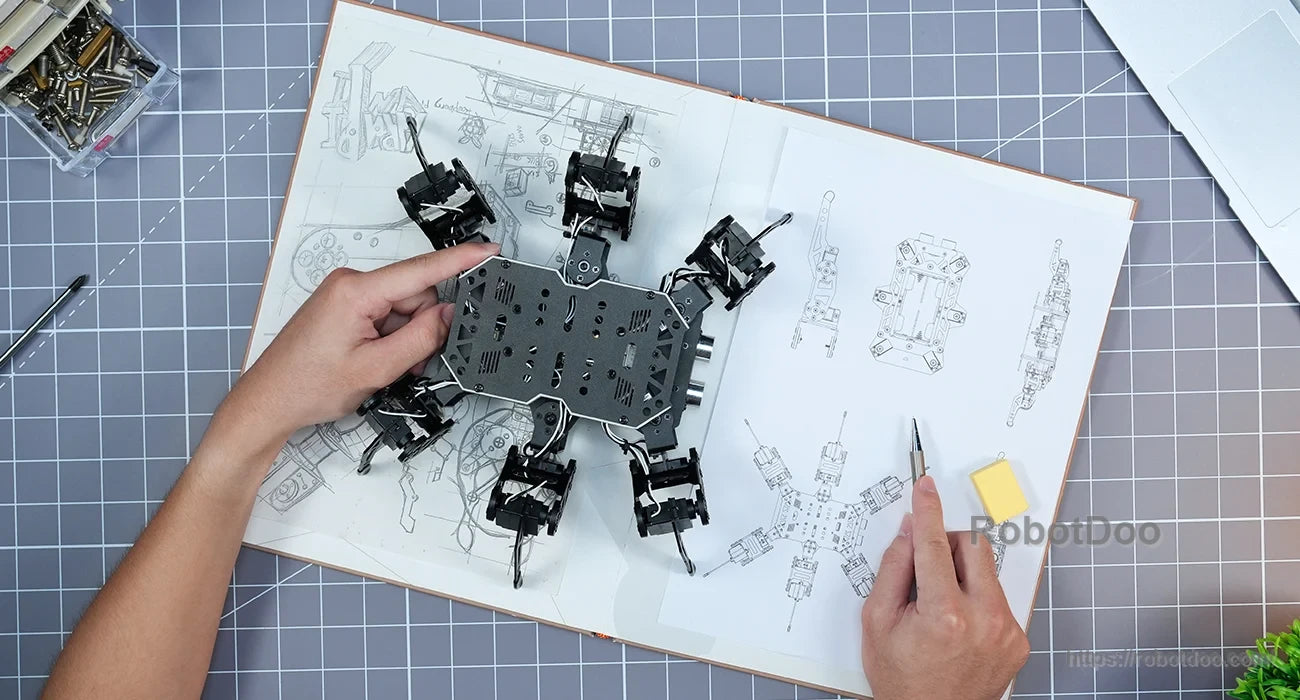 miniHexa hexapod robot assembly and mechanical design drawings on a workbench