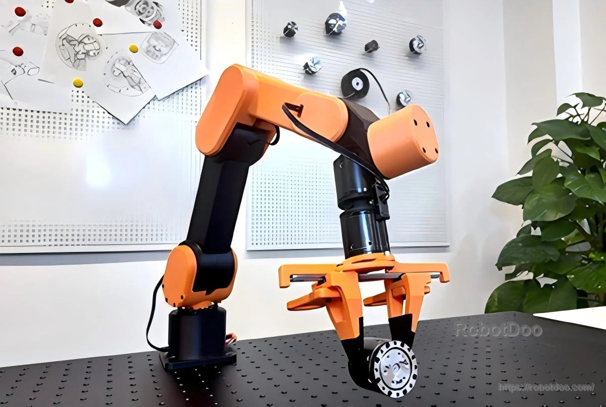 Edulite A3 desktop robotic arm on a perforated workbench, with gripper end effector attached